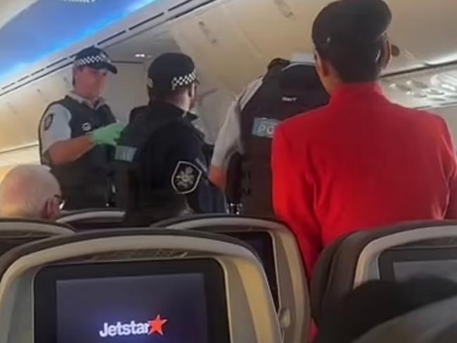 A drunken Jetstar passenger had to be forcibly removed from a flight by police after allegedly directing racist abuse at flight attendants.