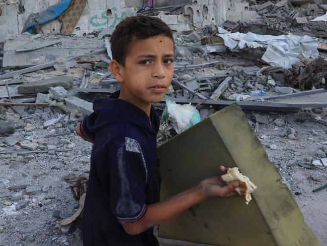 A Palestinian boy salvages belongings from a destroyed home following Israeli bombardment in Rafah in the southern Gaza Strip. Picture: Said Khatib / AFP