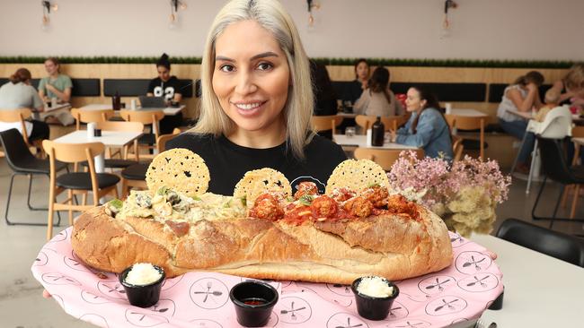 Jennifer Ramos with one of the hefty pasta-filled baguettes at Fork and Spoon cafe in Meadowbank. Picture: Brett Costello