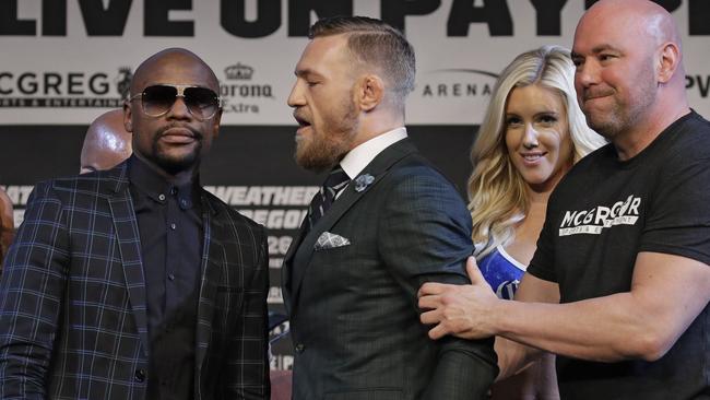 Dana White, right, holds Conor McGregor back from Floyd Mayweather Jr.