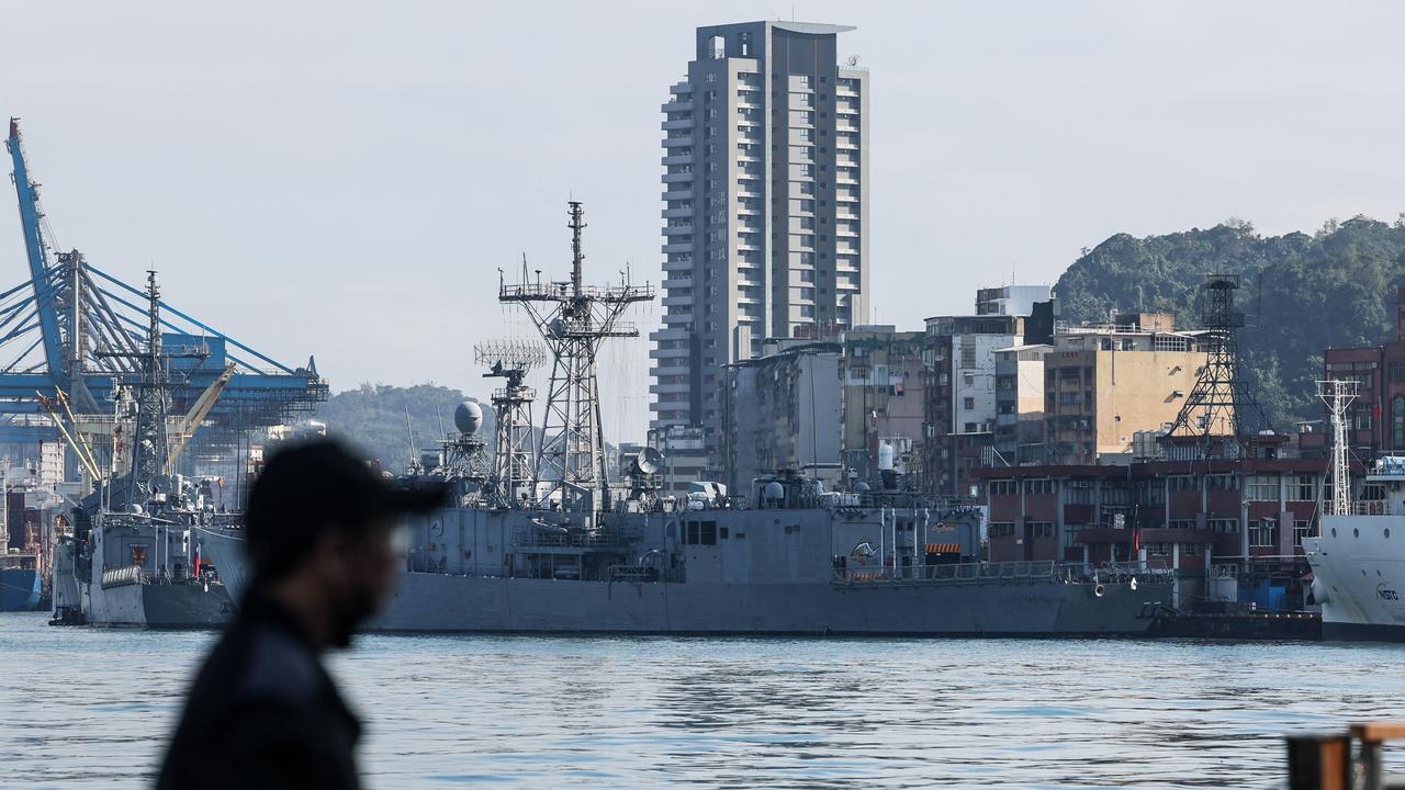 A man stands before Taiwanese Navy ships anchored at the harbour in Keelung on December 11, 2024. Taiwan said on December 11 it had detected 53 Chinese military aircraft and 19 ships near the island in the past 24 hours, as Beijing holds its biggest maritime mobilisation in years. (Photo by I-Hwa CHENG / AFP)