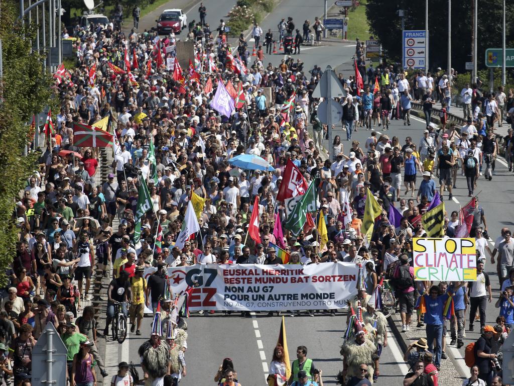 Anti-G-7 activists cross a bridge from Hendaye, France, to Irun, Spain, during a protest Saturday. Picture: AP