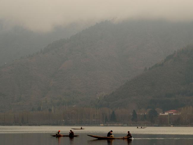 Locals paddle across a misty Dal Lake in shikaras (small boats that ferry tourists to and from houseboats) Picture: Chris Hondros/Getty Images