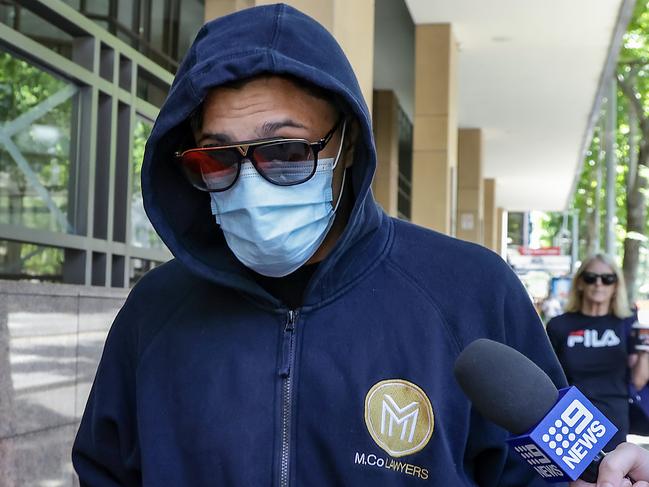 Jack Ziebell’s alleged attacker Ibrahim Behluli with his face covered as he leaves the Melbourne Magistrates’ Court. Picture: Ian Currie