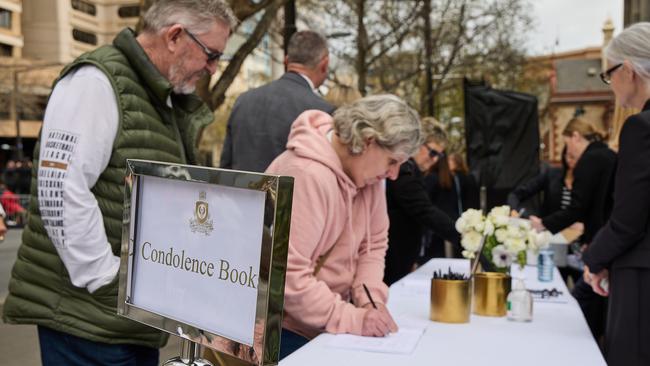 People sign the condolence books. Picture: Matt Loxton