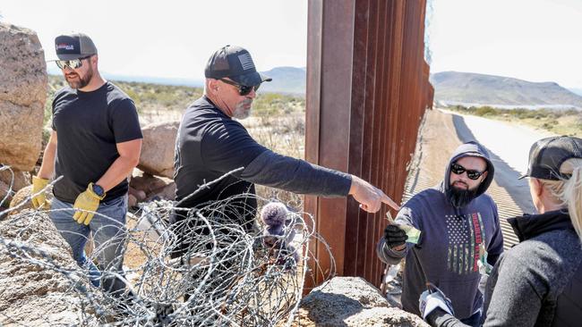 Volunteers with Border Vets help erect barbed wire along the US-Mexico border wall, in Jacumba Hot Springs, California. Border Vets are a group of military veterans concerned with the flow of illegal migrants. Picture: Getty