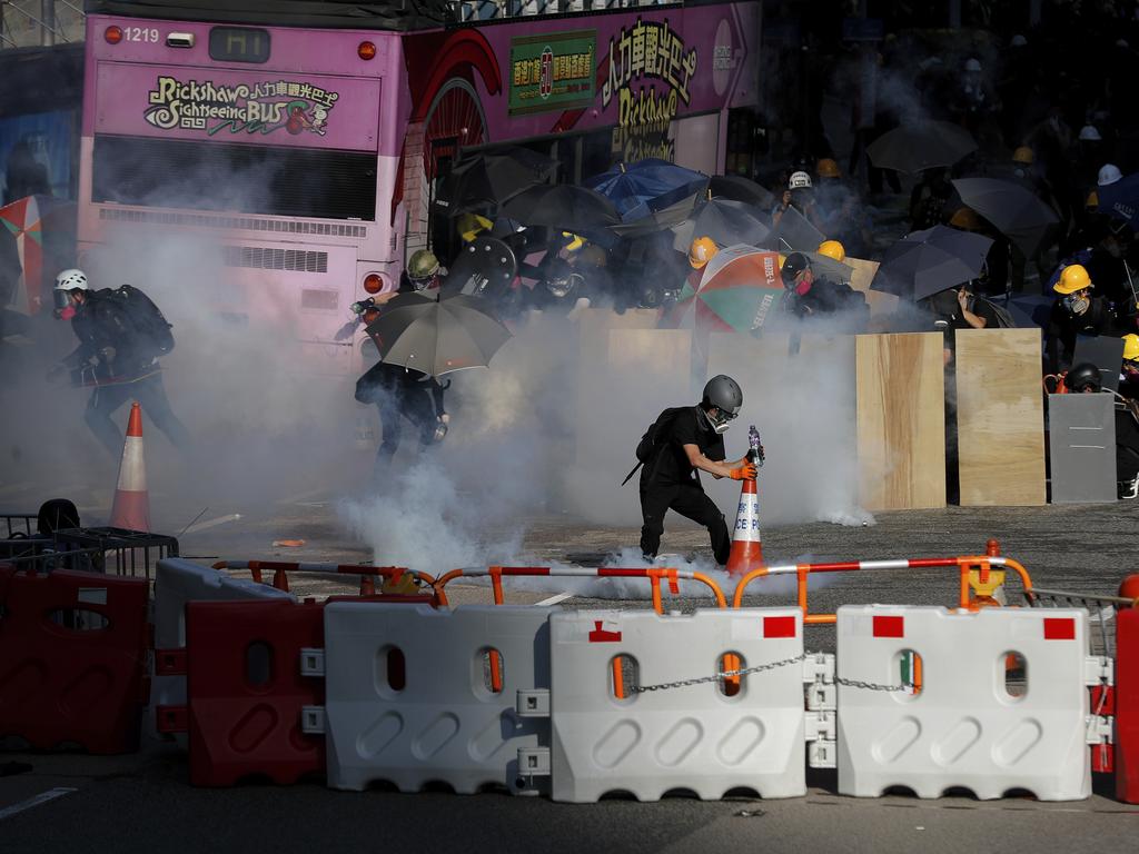 Protesters react from the tear gas fired by riot police as they face off near the Legislative Council building and the Central Government building in Hong Kong. Picture: AFP