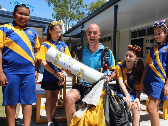 Coolangatta State School students Christian Faigane, Zoe Bird, Mia Joseph and Elissa Dudley talk to former student and Gold Coast Skydiving 'time capsule deliverer Archy Jamieson about the upcoming festivities this weekend. 