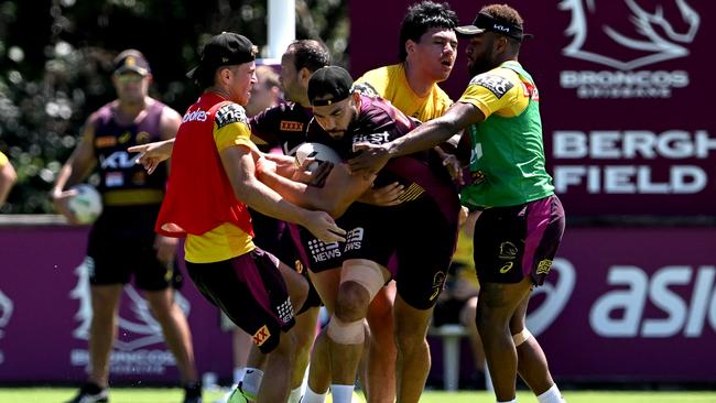 Ryan James tries to bust a tackle at Broncos training.