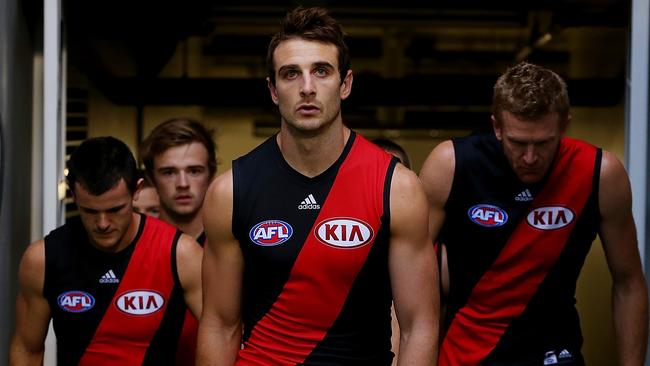 Jobe Watson leads Essendon out onto the ground.