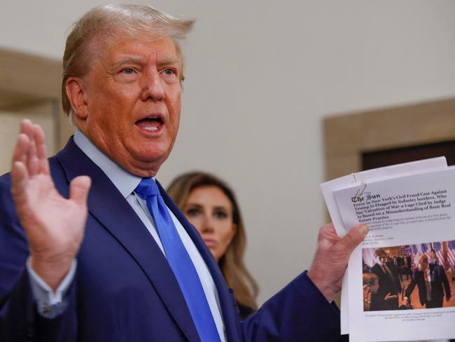 Former president Donald Trump displays a media article outside the court room at the New York State Supreme Court. Picture: AFP