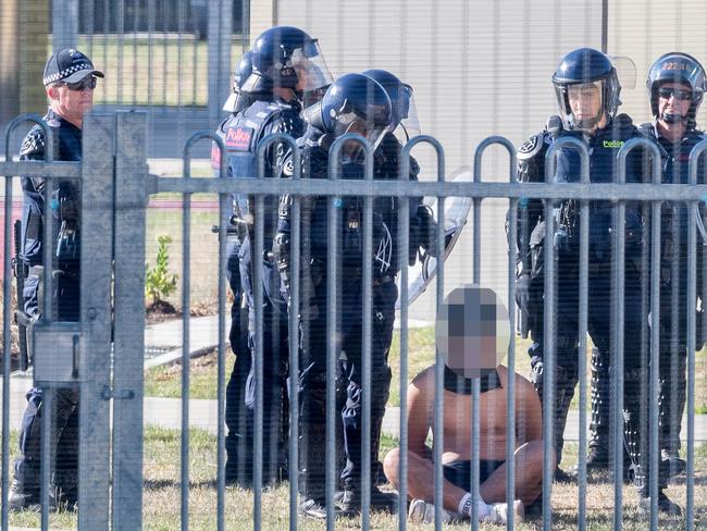 A youth is subdued by police in riot gear. Picture: Jake Nowakowski