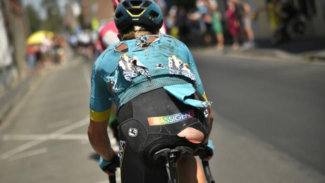 Denmark's Michael Valgren rides on with a ripped jersey.