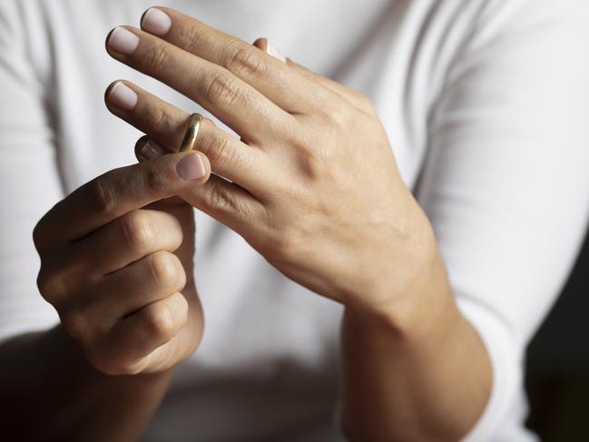 Hands of caucasian female who is about to taking off her wedding ring.