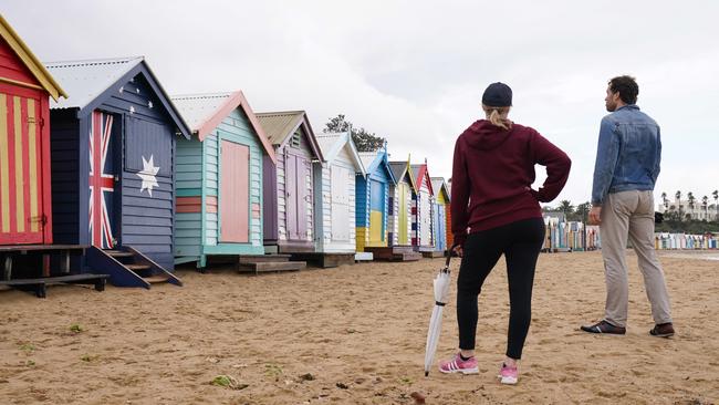 Two people walk on an otherwise empty Brighton Beach yesterday. Picture: AAP Image/Michael Dodge