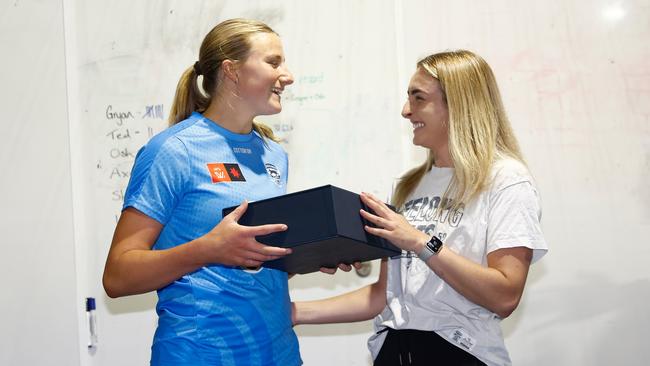 Chantal Mason is presented with her jumper by teammate Amy McDonald ahead of her debut. Picture: Michael Willson/AFL Photos via Getty Images