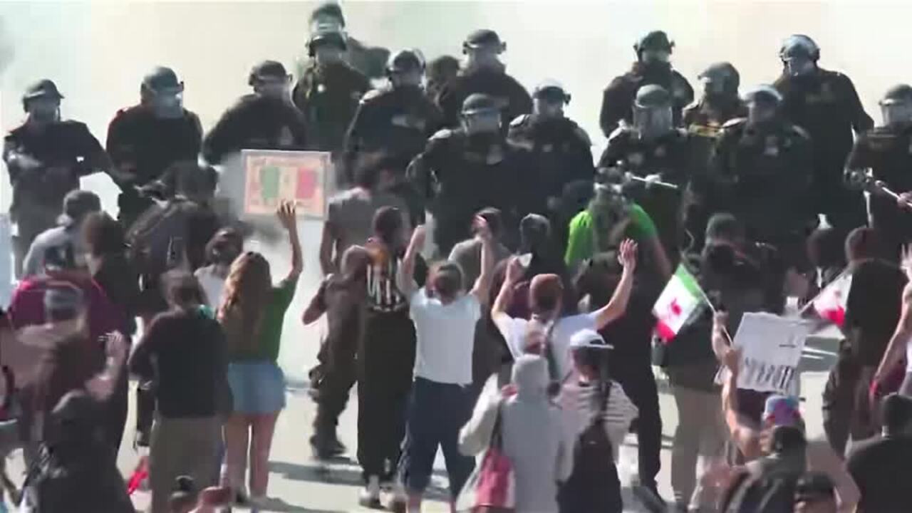 Protesters and police officers face off on LA freeway