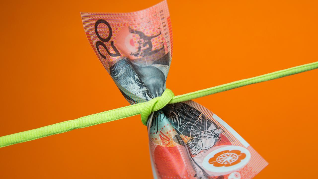 Australian twenty dollar note tied in a knot on a plain background, money generic squeeze pressure