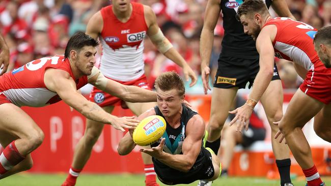 Ollie Wines of the Power handballs during the round one win against Sydney.