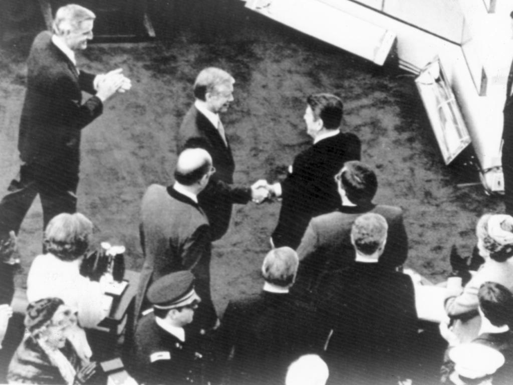 Jimmy Carter shakes hands with Mr Reagan at his inauguration as President in 1981.