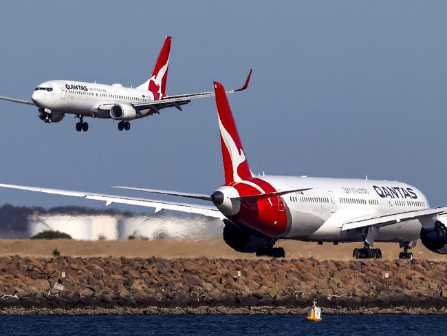 This photo taken on September 4, 2024 shows a Qantas Airways Boeing 737-800 plane coming in to land next to a Qantas Airways Boeing 787 Dreamliner aircraft preparing to take-off at Sydney International Airport. (Photo by DAVID GRAY / AFP)