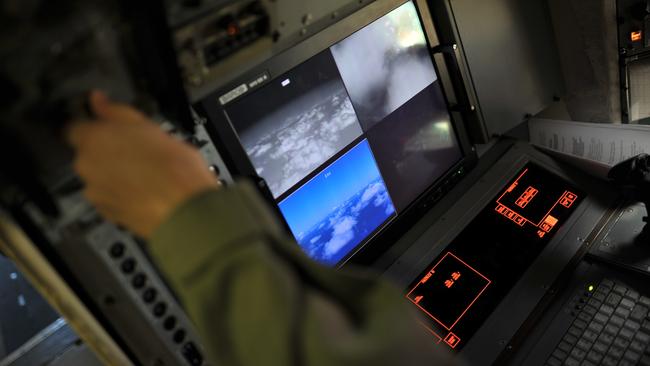 A member of the crew of a US Navy Lockheed P-3C Orion patrol aircraft from Sigonella, Sicily, scans the area in the Mediterranean Sea where EgyptAir flight MS804 went missing. Picture: AP/Salvatore Cavalli