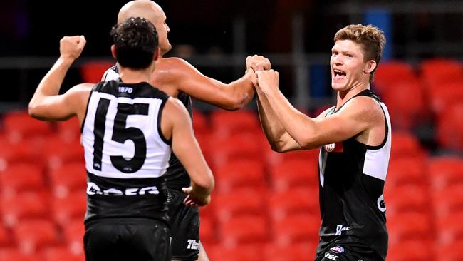 Georgiades (right) celebrates kicking his first AFL goal against Gold Coast in round one with Port Adelaide teammates Karl Amon (No. 15) and Sam Powell-Pepper. Picture: Darren England/AAP