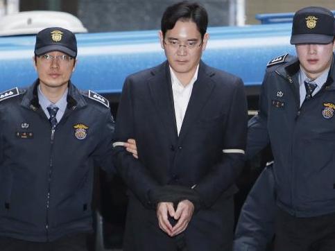Lee Jae-yong is led into the office of the independent counsel in Seoul.