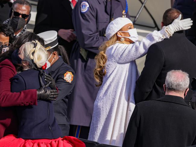 Former First Lady Michelle Obama, left, hugs Lady Gaga as Jennifer Lopez, centre, greets former New York Yankee Alex Rodriguez during the inauguration. Picture: Getty Images