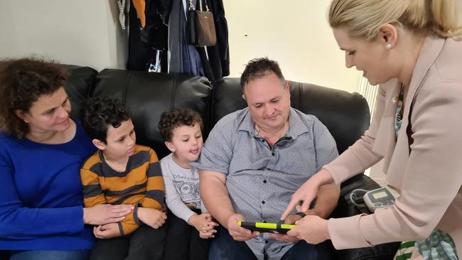 Deputy chief public health officer Emily Kirkpatrick shows Simon and Angelo Katsilis – with sons Stavro, 8, and Dimitri, 4 – how to use the equipment. Picture: Elizabeth Henson