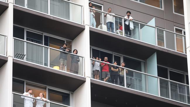 Quarantined travellers line the balconies of the Pullman Hotel to watch Hans and his band. Picture: Russell Millard