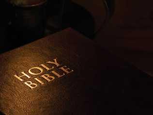 A moody image of The Holy Bible next to a candle. Perfect for Easter or Christmas theme.