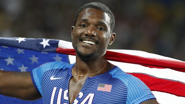 USA's Justin Gatlin holds up his national flag as he celebrates after coming in second in the Men's 100m Final during the athletics event at the Rio 2016 Olympic Games at the Olympic Stadium in Rio de Janeiro on August 14, 2016. / AFP PHOTO / Adrian DENNIS