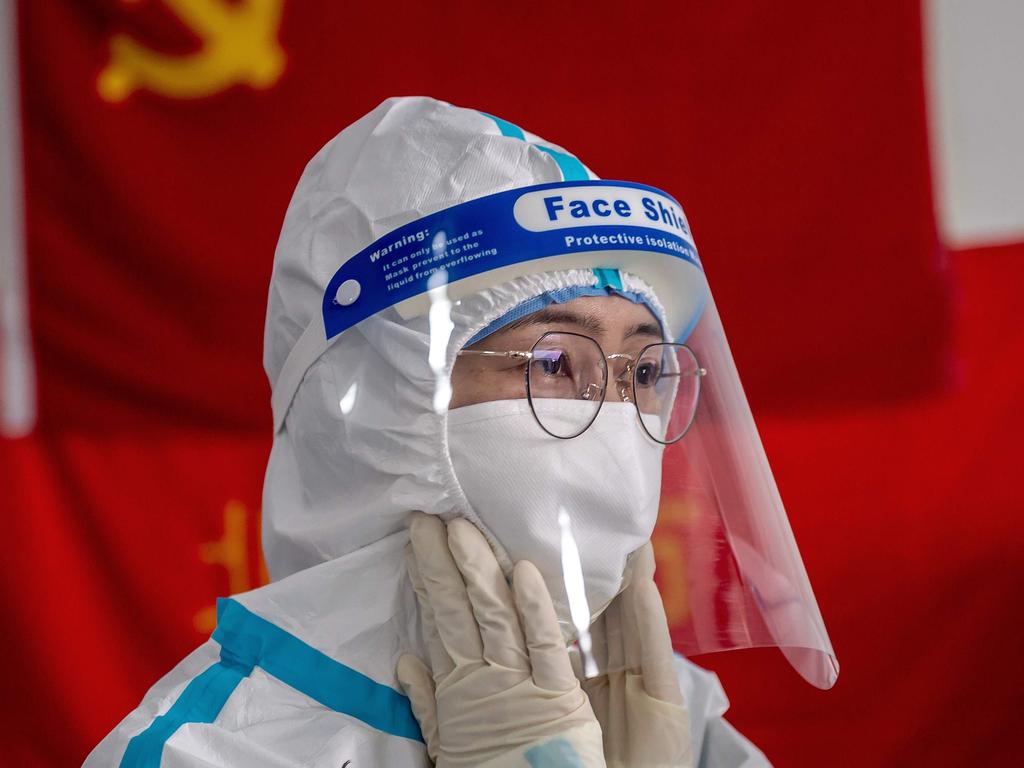 China has retaliated against Australia for suggesting an inquiry into the origins of COVID19. Pictured, a medic prepares for her shift in beihing. Picture: by NICOLAS ASFOURI / AFP.