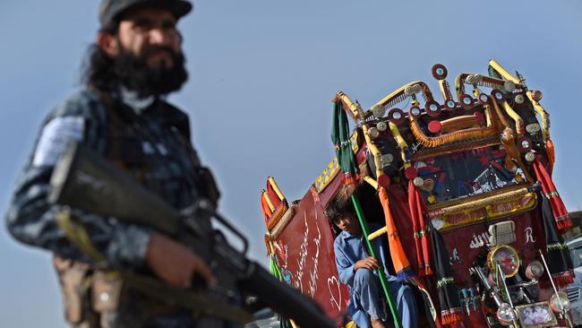 A Taliban fighter working as part of a police force checks commuters at a road checkpoint in Kabul. Picture: AFP