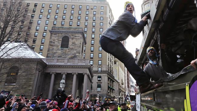 New England Patriots tight end Rob Gronkowski hangs out of a duck boat as fans cheer during a Super Bowl XLIX victory parade in Boston.