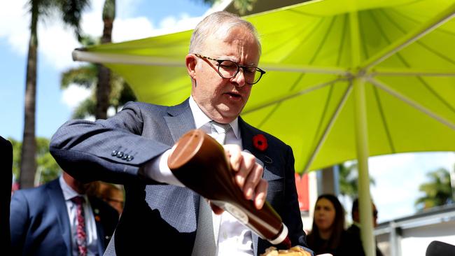 Anthony Albanese puts sauce on a hotdog at a BBQ after a citizenship ceremony to welcome New Zealanders as Australians. Picture: AFP.