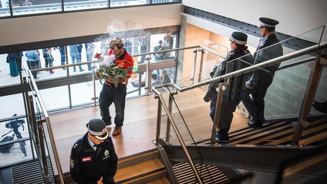 Darug elder Lex Dadd leads police through the new Mt Druitt police station during Tuesday’s smoking ceremony. Picture: BGIS