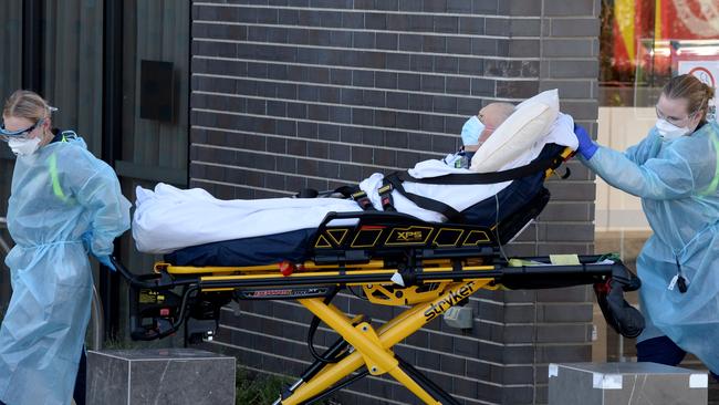 A resident is transferred from Epping Gardens aged care home to an ambulance. Picture: Andrew Henshaw