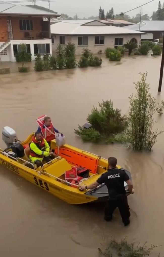 Julie Buckley being escorted into Ingham by SES boat and police. Picture: Supplied.