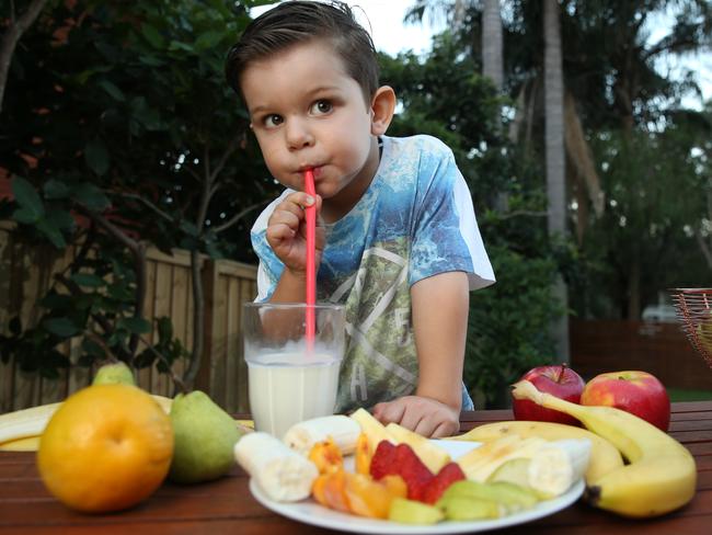 Now this is a healthy breakfast. Zack, 3, tucks into fruit and milk to start his day. Picture: Tim Hunter