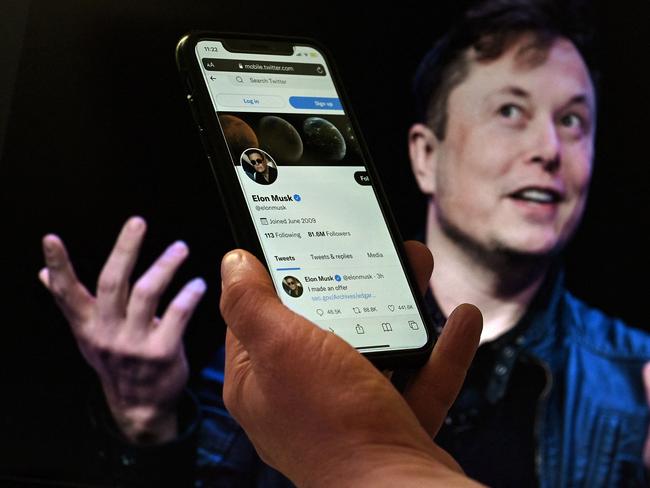 (FILES) In this April 14, 2022 file photo illustration, a phone screen displays the Twitter account of Elon Musk with a photo of him shown in the background in Washington, DC. - Twitter reported disappointing results on July 22, 2022, a miss that the social network attributed to "headwinds" including the uncertainty related to Elon Musk's buyout bid. The firm is locked in a legal battle with the mercurial Tesla boss over his effort to walk away from his $44 billion deal to purchase the platform, leaving the company in limbo. Twitter missed expectations with revenue of $1.18 billion, due to "advertising industry headwinds... as well as uncertainty related to the pending acquisition of Twitter by an affiliate of Elon Musk," the firm reported. (Photo by Olivier DOULIERY / AFP)