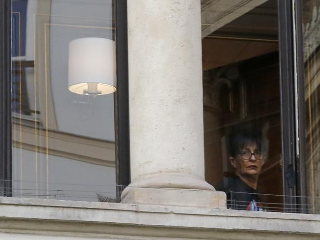 A woman looks out the window of the place the reality star was staying. Picture: Michel Euler