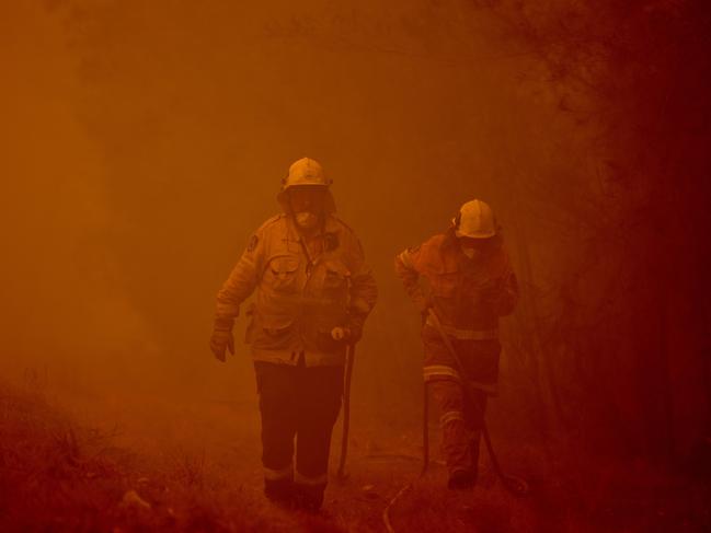 Firefighters tackle a bushfire in thick smoke in the town of Moruya, south of Batemans Bay, on January 4. Picture: Peter Parks/AFP