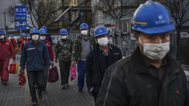 Chinese construction workers clock off for the day in Beijing.