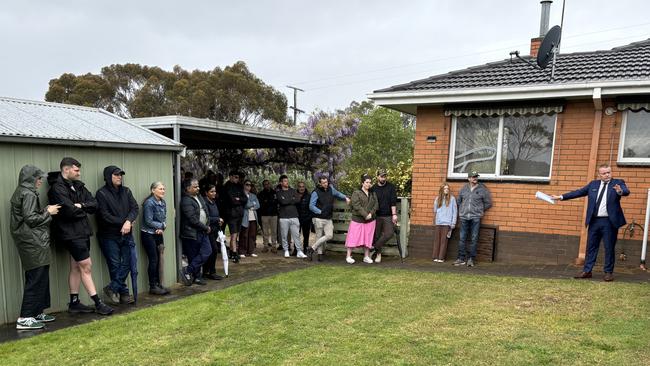 McGrath, Geelong agent David McGuinness indicates a bidder in the crowd.