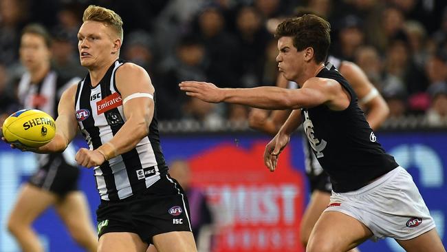 Paddy Dow chases Adam Treloar during his big day against the Pies. Pic: AAP