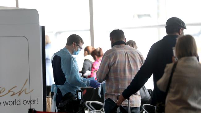 People get health checks at Sydney Airport on Sunday. Picture: Damian Shaw