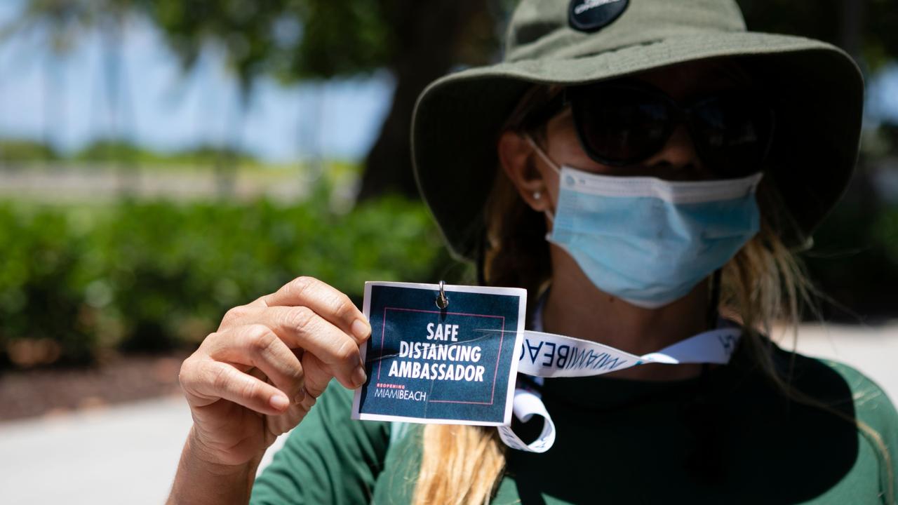 A Miami Beach worker shows her badge as Safe Distancing Ambassador. Picture: Eva Marie Uzcategui/AFP