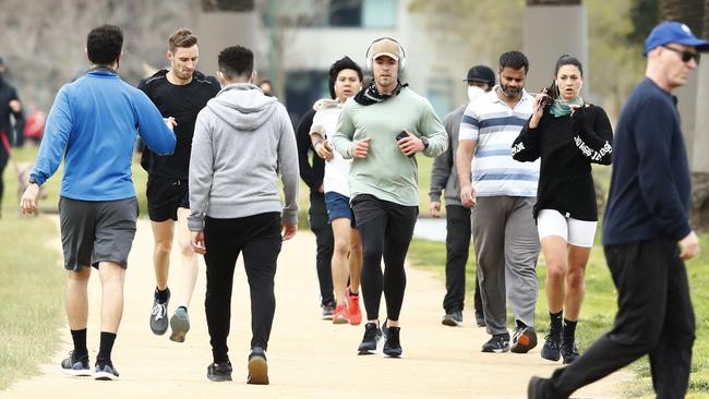 Runners, many unmasked, exercise at Albert Park on Sunday. Picture: Darrian Traynor/Getty Images